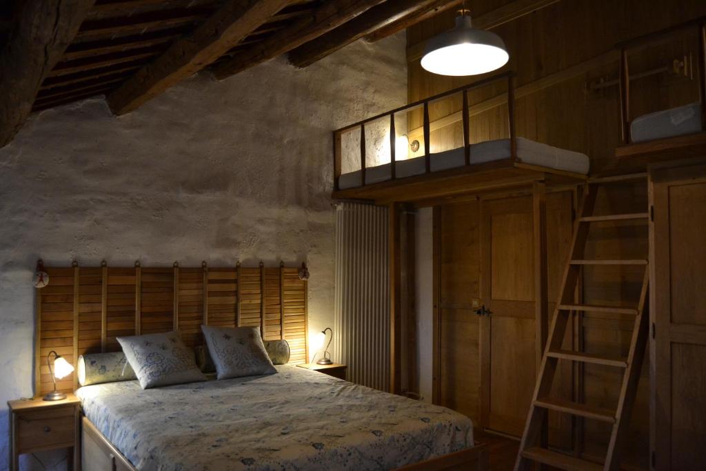 a bedroom with a bed and a loft bed with a ladder at Regina Sconta in Villa Estense