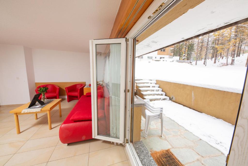 a living room with a red couch and a window at Haus Alfa in Saas-Fee
