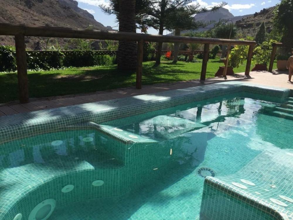 a large swimming pool with blue water at Villa Ayagaures in Los Palmitos