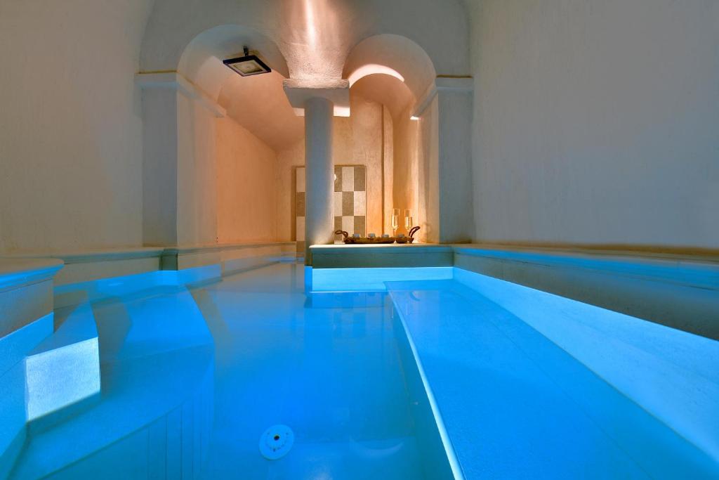 una piscina cubierta de agua azul en un edificio en THE A COLLECTION by K&K, en Oia