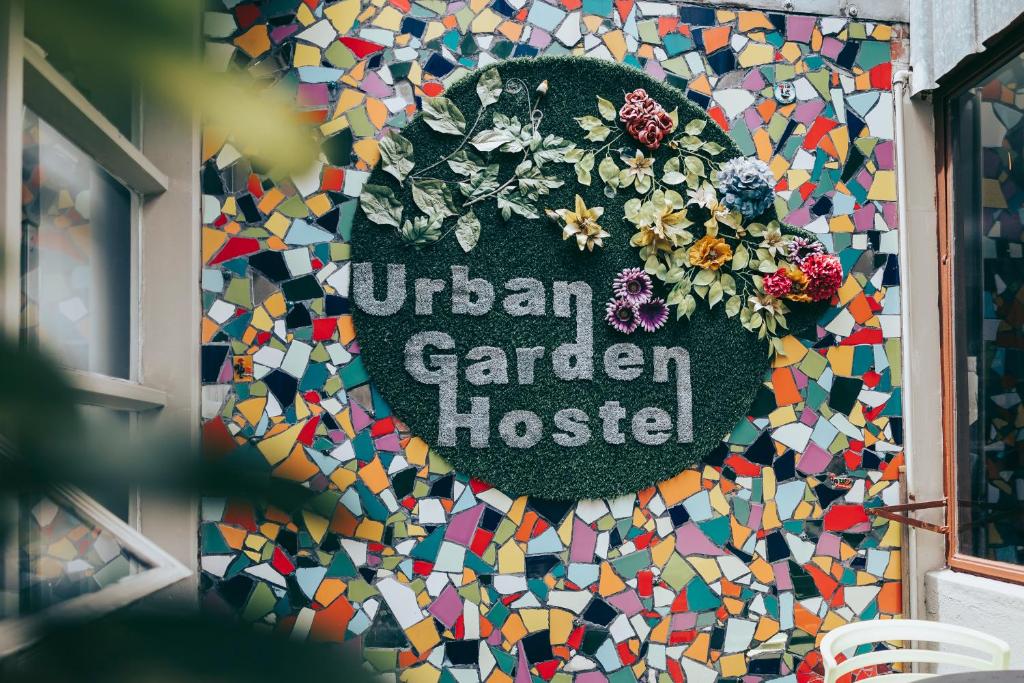 a sign on a building with a colorful mosaic wall at Urban Garden Hostel in Lisbon