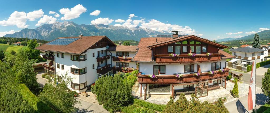 an aerial view of a house with mountains in the background at Sporthotel Schieferle in Innsbruck