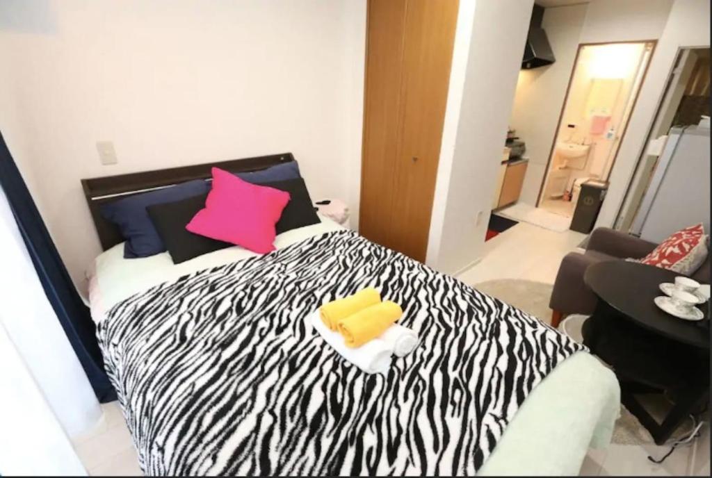 1 dormitorio con 1 cama con estampado de cebra y 2 almohadas en Kamiya TK Building 202, en Tokio
