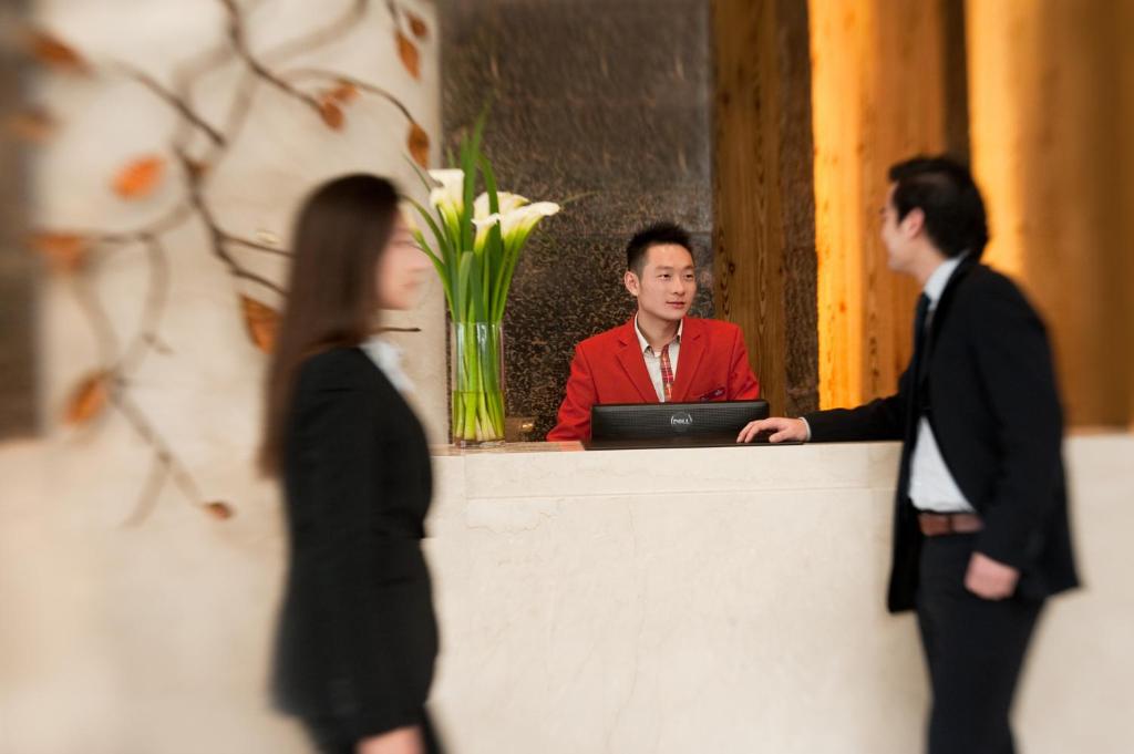 a man sitting at a desk with a laptop at Crowne Plaza Shanghai Anting, an IHG Hotel - 15 minutes drive to FE in Jiading