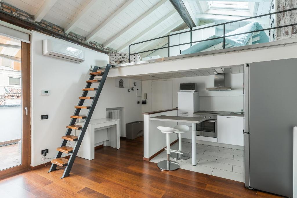 cocina con escalera de caracol y loft en In Our Home by Holiday Solutions en Como