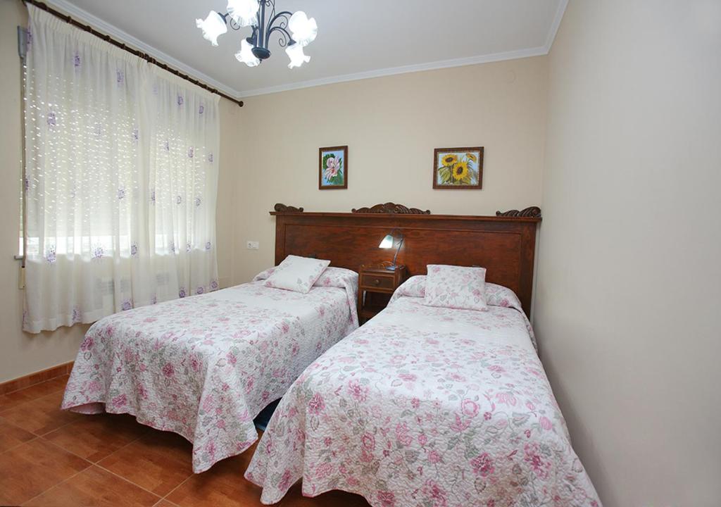 a bedroom with two beds and a window at Pensión Casa Elena in Reinante