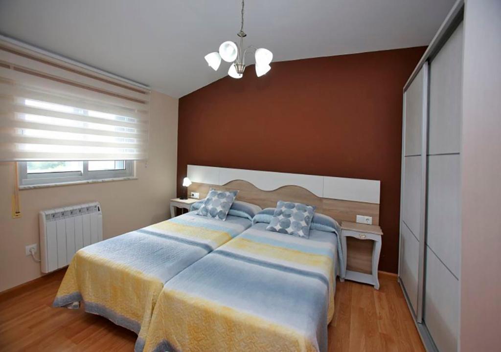 a bedroom with a large bed and a brown wall at Pensión Casa Elena in Reinante