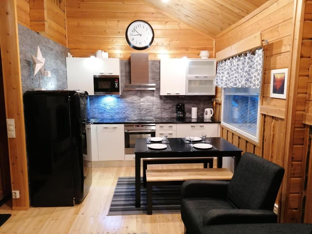 Hippu Apartment في روكا: مطبخ مع طاولة وساعة على الحائط
