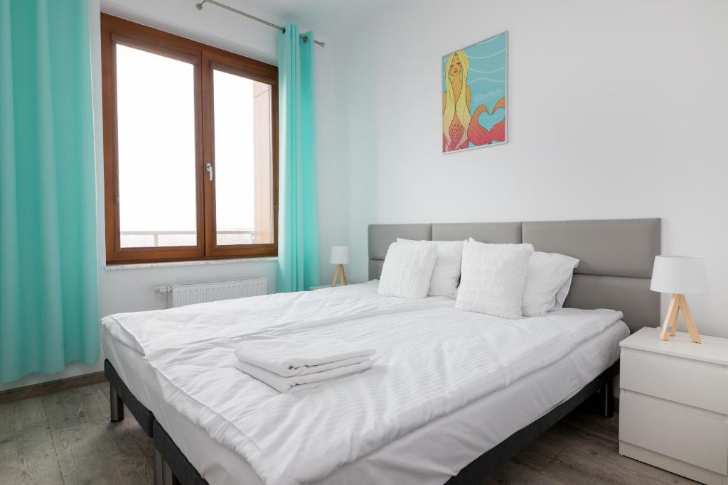 - un grand lit blanc dans une chambre aux murs bleus dans l'établissement Royal Palace Elegant Apartment, à Varsovie