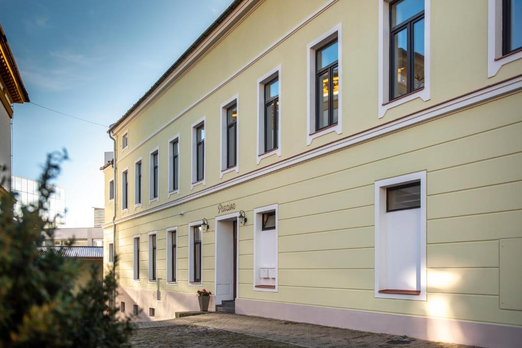 a yellow building with white doors and windows at Penzion Stará pošta in Frýdek-Místek