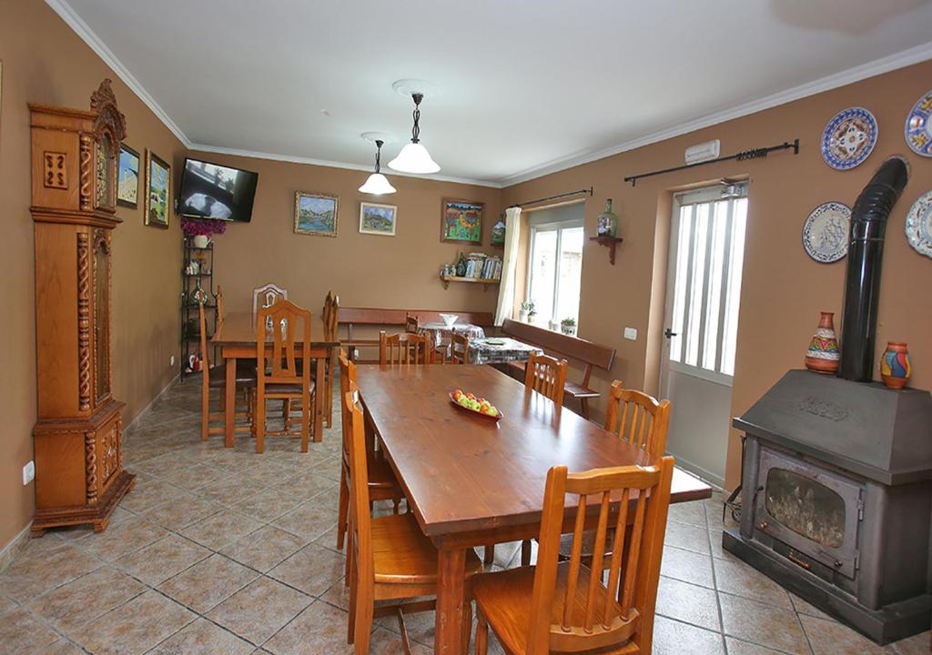a dining room with a table and chairs and a fireplace at Pensión Casa Elena in Reinante