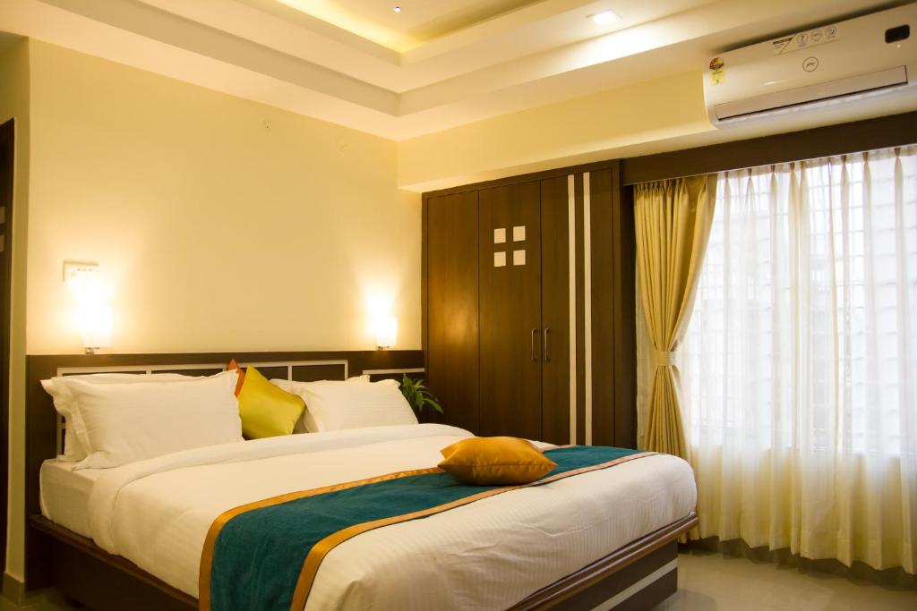 1 dormitorio con 2 camas y ventana en Hotel Park Riviera, en Guwahati