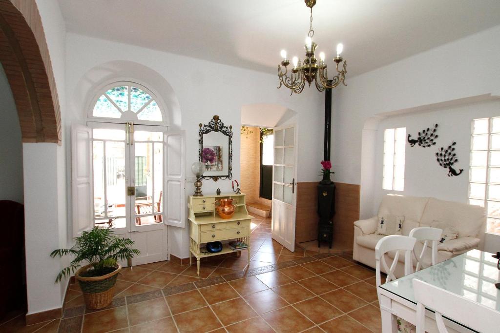 uma sala de estar com um lustre e uma mesa em Casa Rural Mérida em Aljucén