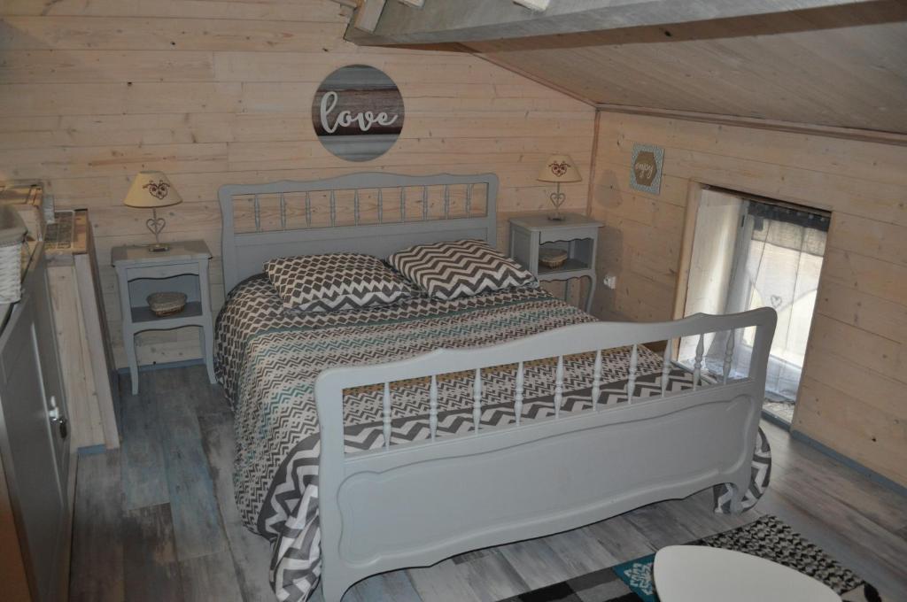 um quarto com uma cama branca e paredes de madeira em le studio d'Oihana em Lauzun