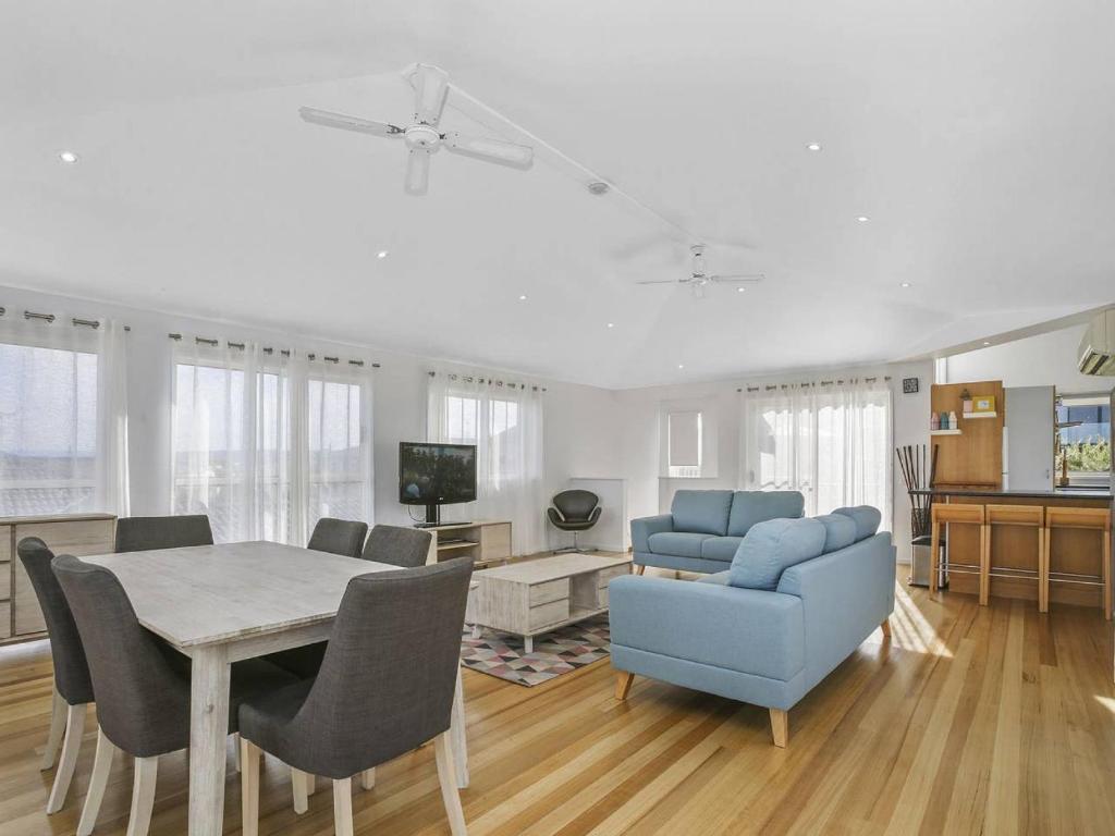 a living room with a table and a blue couch at SEAVIEW - ocean views from a modern townhouse in Apollo Bay