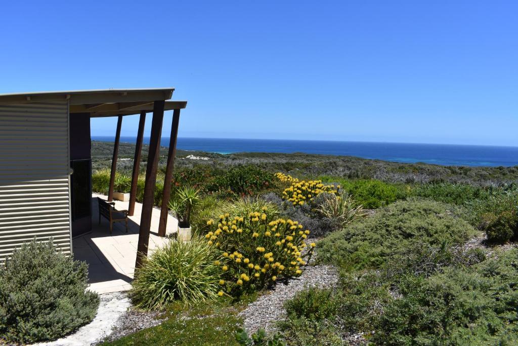 um jardim com flores amarelas ao lado de um edifício em Redgate Beach Escape em Witchcliffe