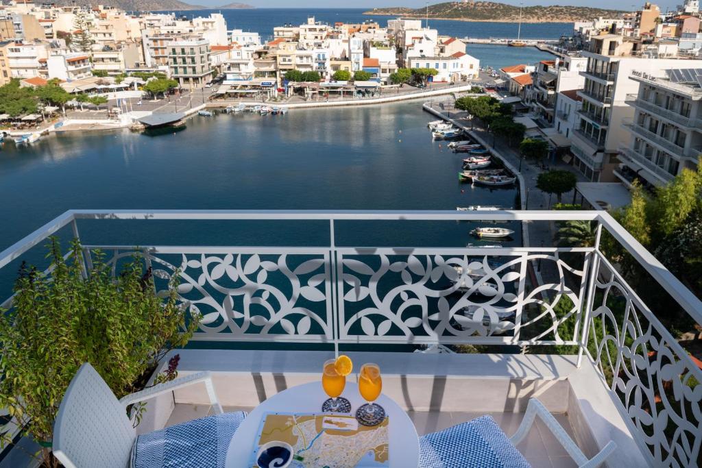 a balcony with a table and a view of the water at Emerald Lake Studios in Agios Nikolaos