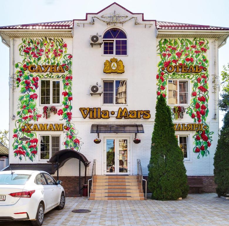 a white building with a white car parked in front of it at Villa Mars Krasnodar in Krasnodar