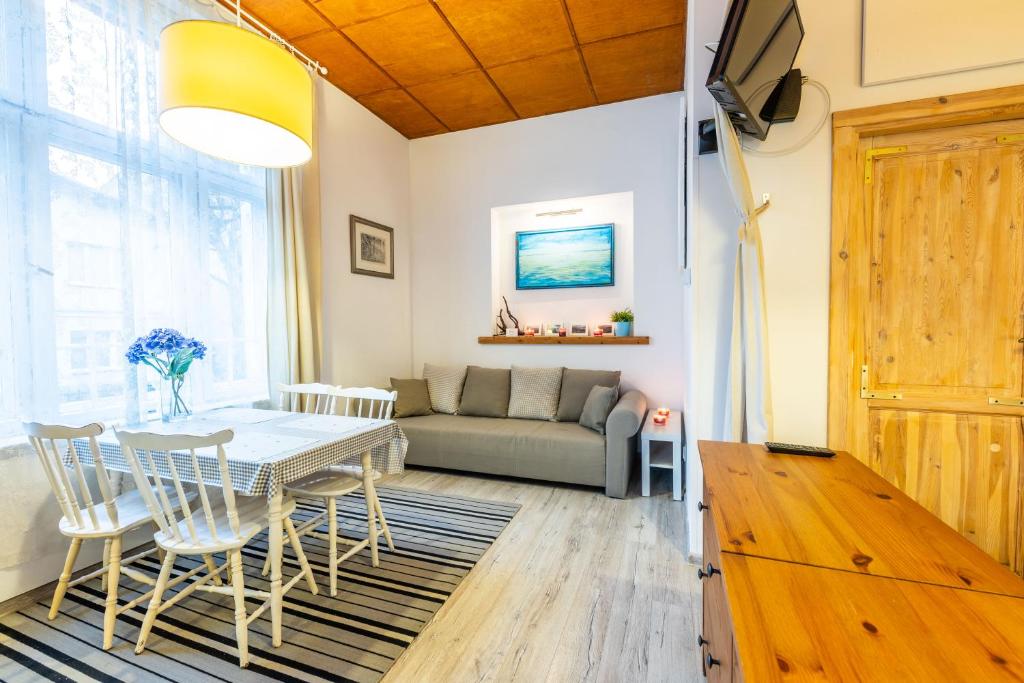 uma sala de estar com uma mesa e um sofá em Victus Apartamenty, Victus Apartament Fiord em Sopot