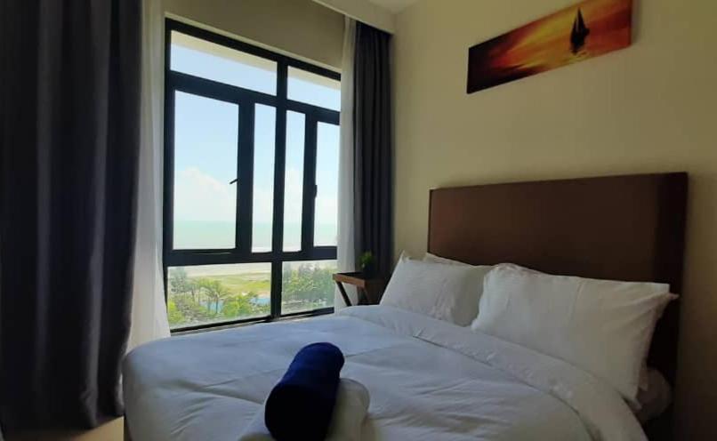 a stuffed animal laying on a bed with a window at NRA @TimurBay Seafront Residence in Kuantan