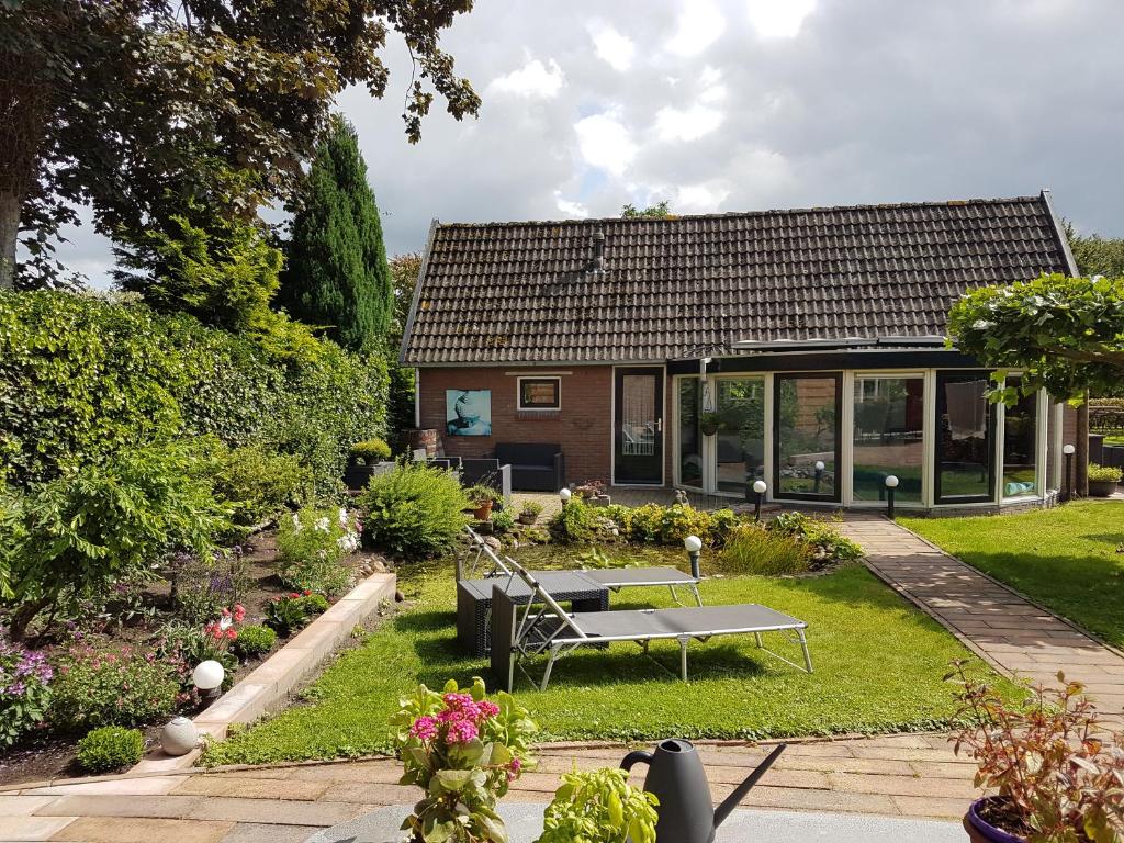 a garden with a bench in front of a house at Hakuna Matata Peddelenzo in Kiel