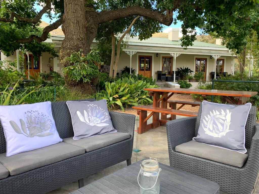 un patio con 2 divani e un tavolo da picnic di Montagu Vines Guesthouse a Montagu