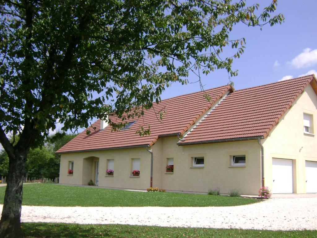 une maison blanche avec un toit rouge dans l'établissement La ferme de la Velle, à La Neuvelle-lès-Scey