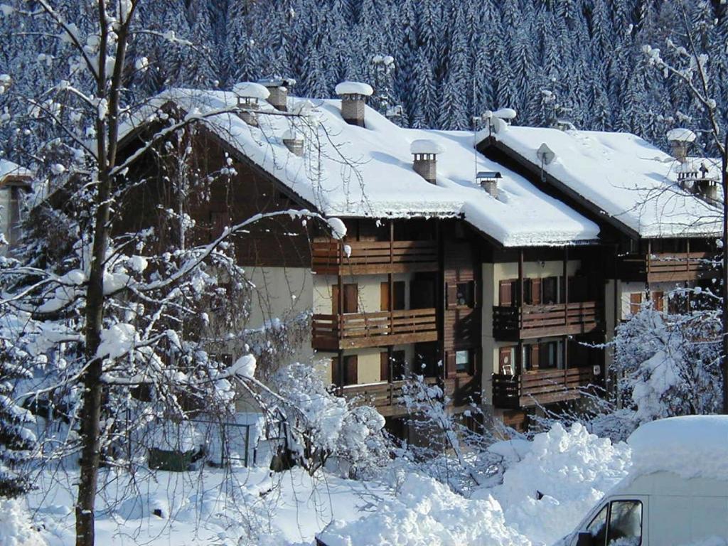 una cabaña de madera en la nieve con árboles nevados en Val Fassa, en Campitello di Fassa