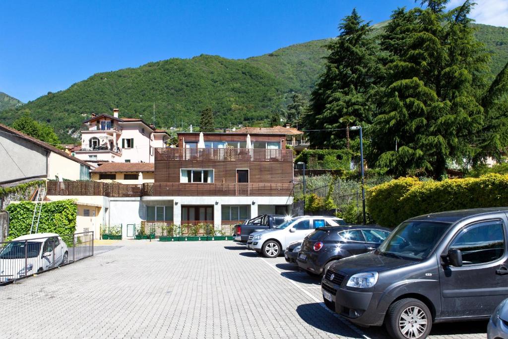 a parking lot with cars parked in front of a house at Residence Lenno in Lenno