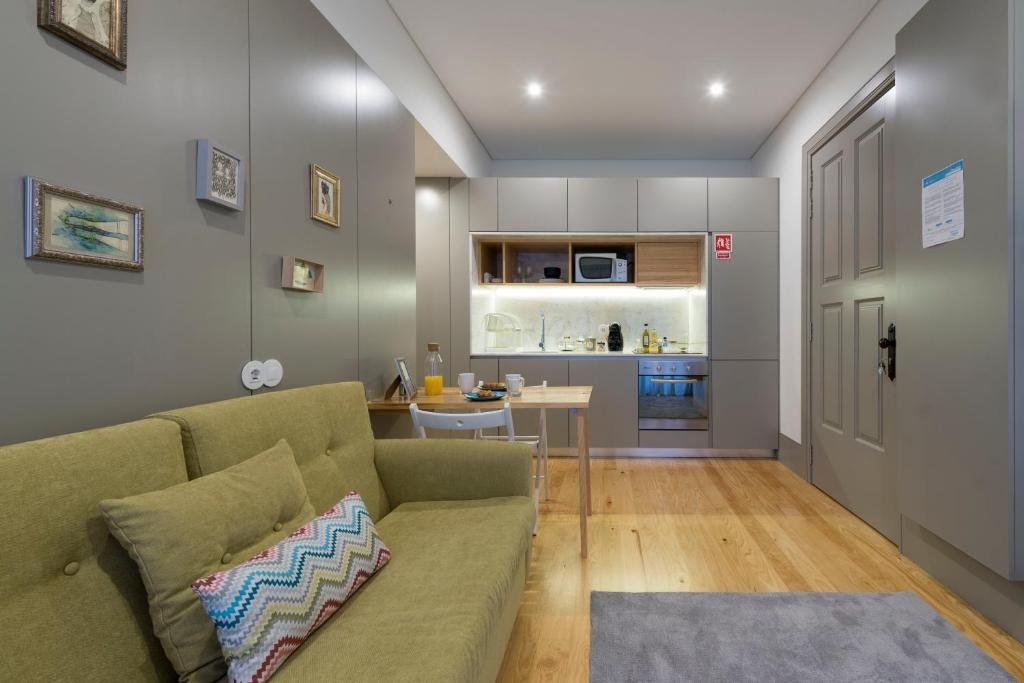 een woonkamer met een bank en een keuken bij LovelyStay - Stylish Central Apartment by Bolhão Market in Porto