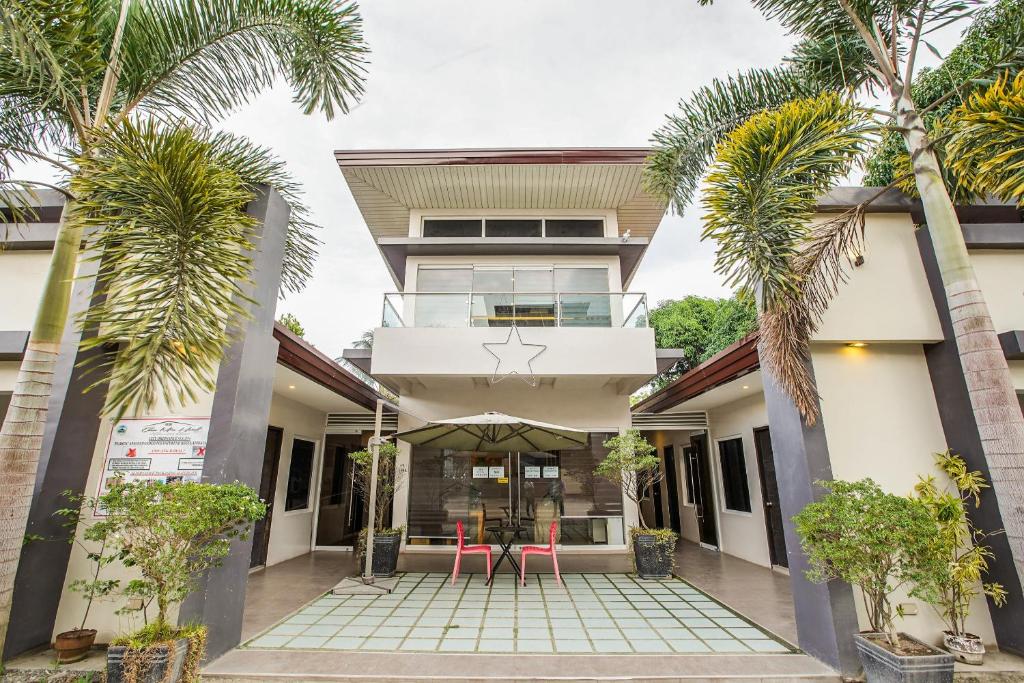 uma vista para a frente de uma casa com palmeiras em OYO 489 Casa Mia Hotel Suites em General Santos