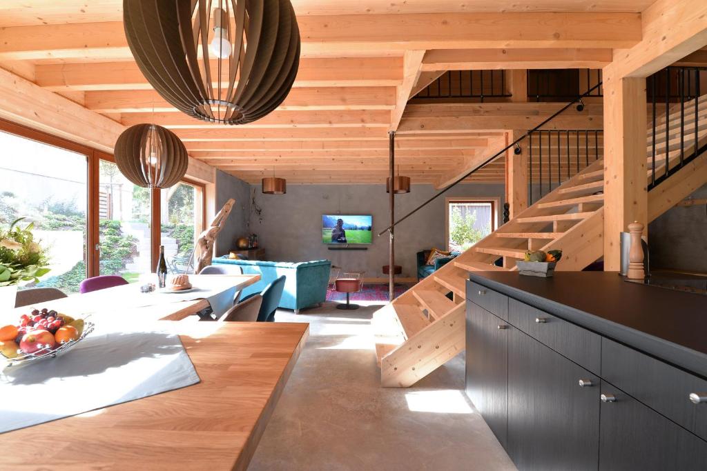 uma cozinha e sala de estar com uma escada em espiral em Les Granges Modernes em Bruebach