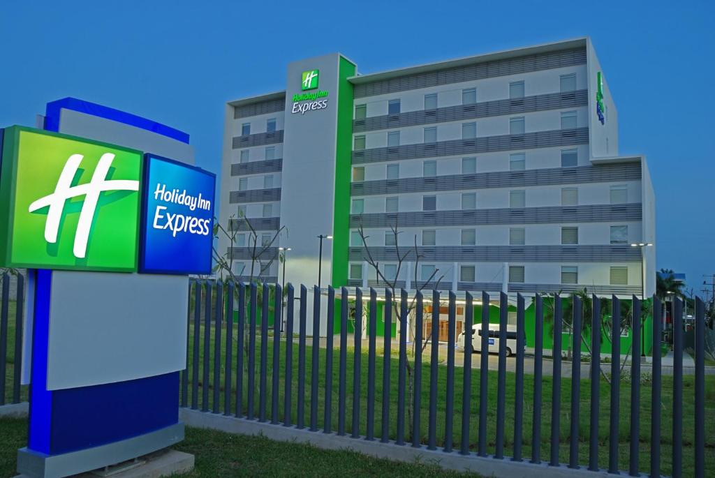 budynek z tabliczką przed płotem w obiekcie Holiday Inn Express Managua, an IHG Hotel w mieście Managua