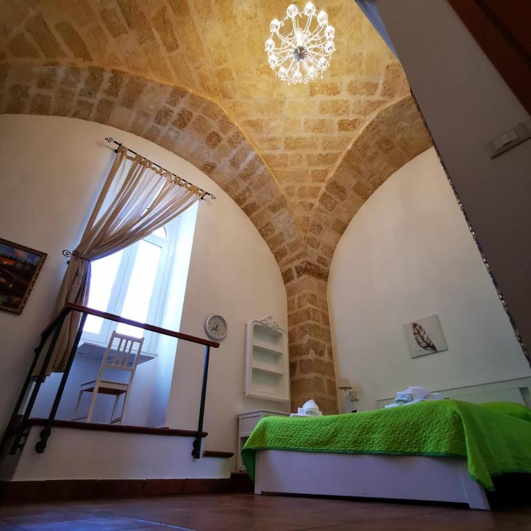 Zimmer mit einem Bett und einem Fenster mit einem Kronleuchter in der Unterkunft room n.22 suite & apartment in Taranto