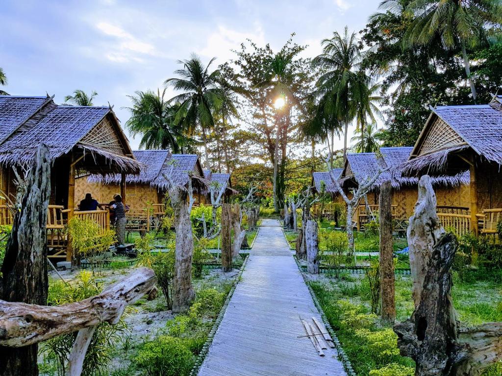 um caminho em frente a um resort com palmeiras em Koh Mook Bungalows em Ko Mook