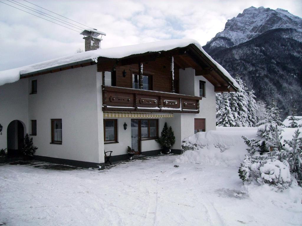 a house in the snow with a mountain at Haus Früh in Telfes im Stubai