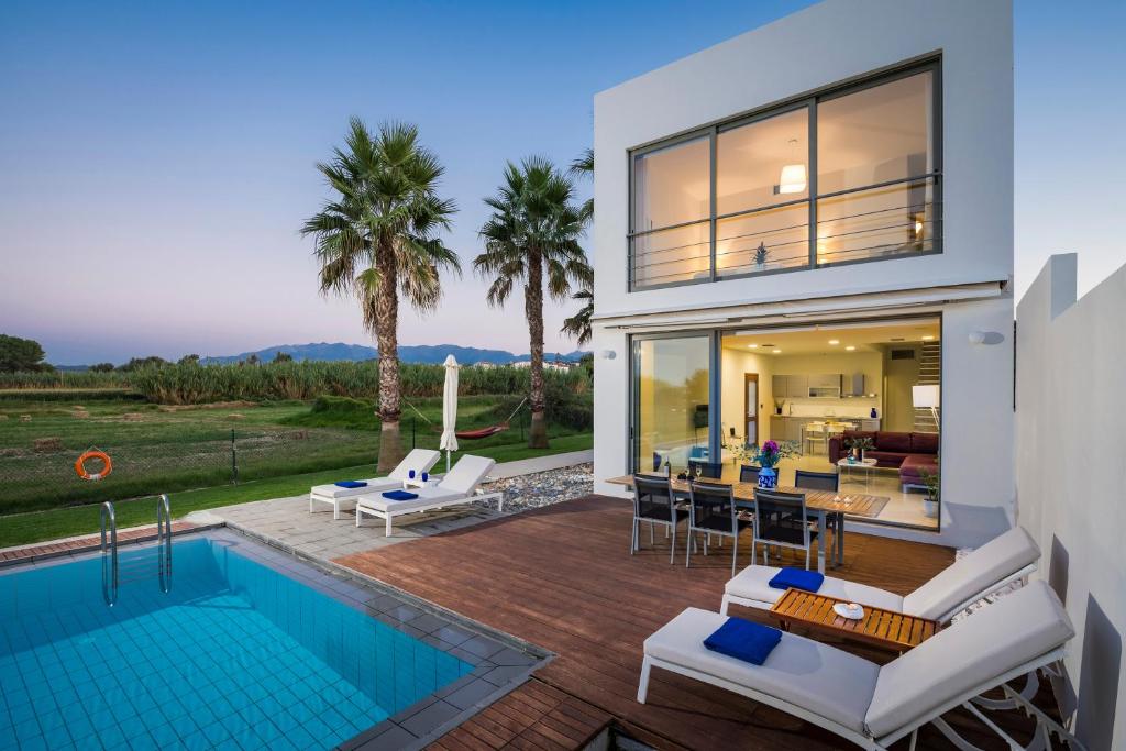 マレメにあるBlue Sea Luxury Villaのスイミングプールとパティオ付きの家