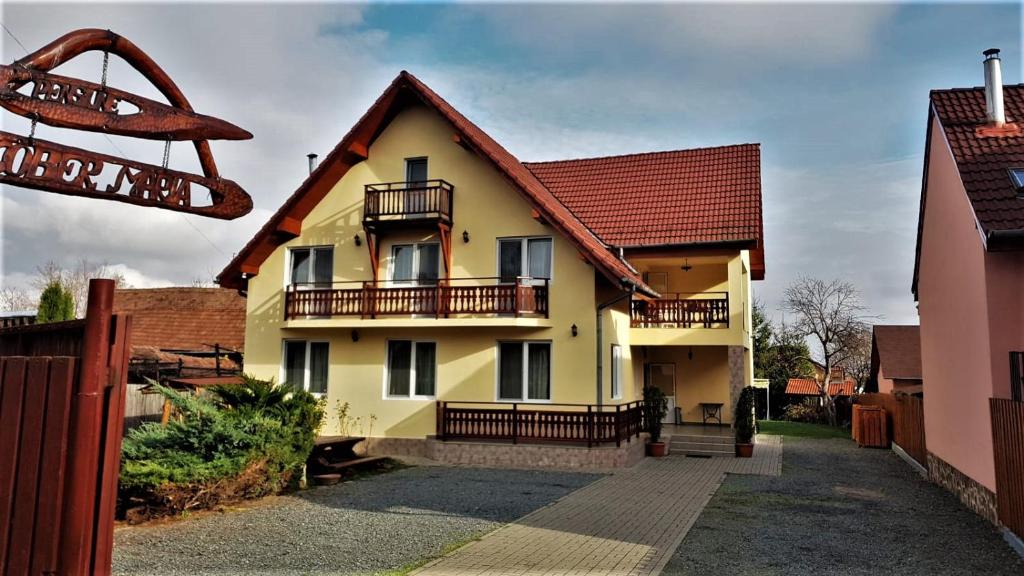 a yellow house with a red roof at Pensiunea Maria Köber in Gura Rîului