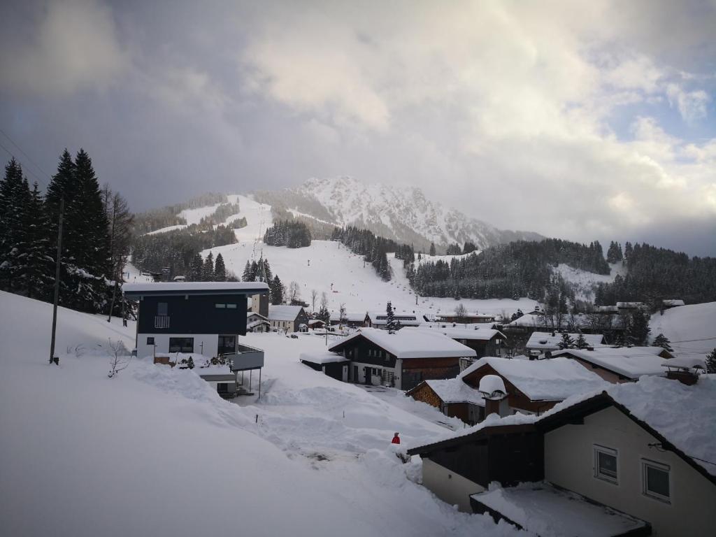 a snow covered village with a mountain in the background at Jungholz Erlebnis in Jungholz