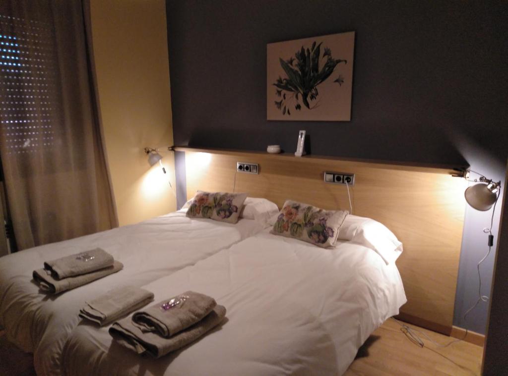 a bedroom with a large white bed with towels on it at Apartamento Barqueros, 2 in Salamanca