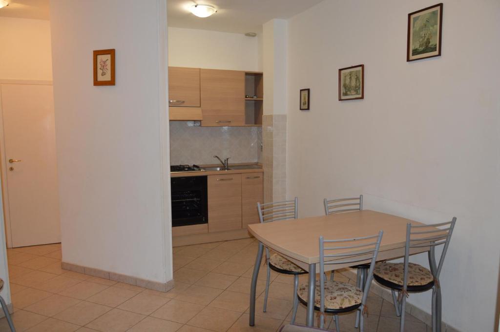 una cucina con tavolo e sedie in una stanza di Casa Grazia a soli 100m dal mare Marina di Castagneto a Marina di Castagneto Carducci