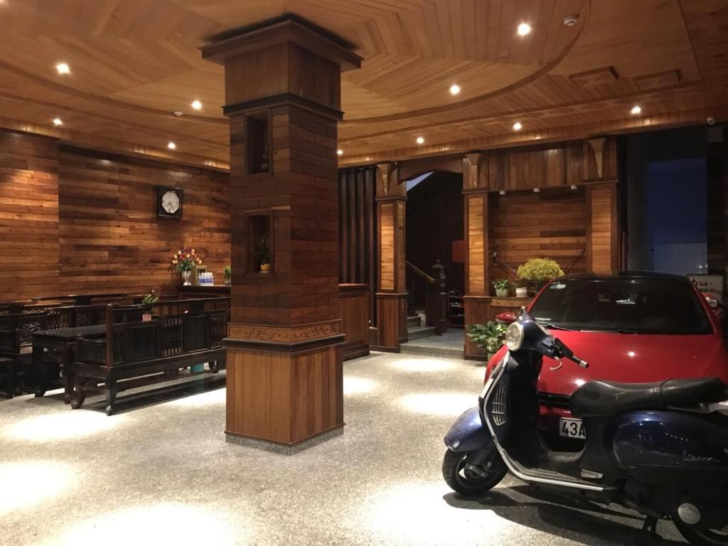 uno scooter parcheggiato in una stanza con orologio. di Salyna Motel a Da Nang