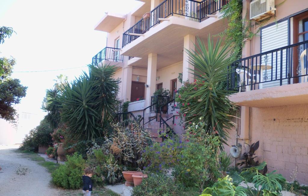 a person standing in front of a building with plants at Nikolas Apartments in Kato Daratso