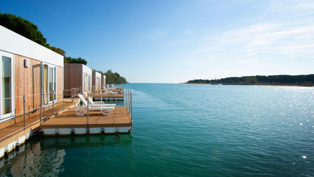 un muelle sobre un cuerpo de agua con un edificio en Marina Uno Floating Resort, en Lignano Sabbiadoro