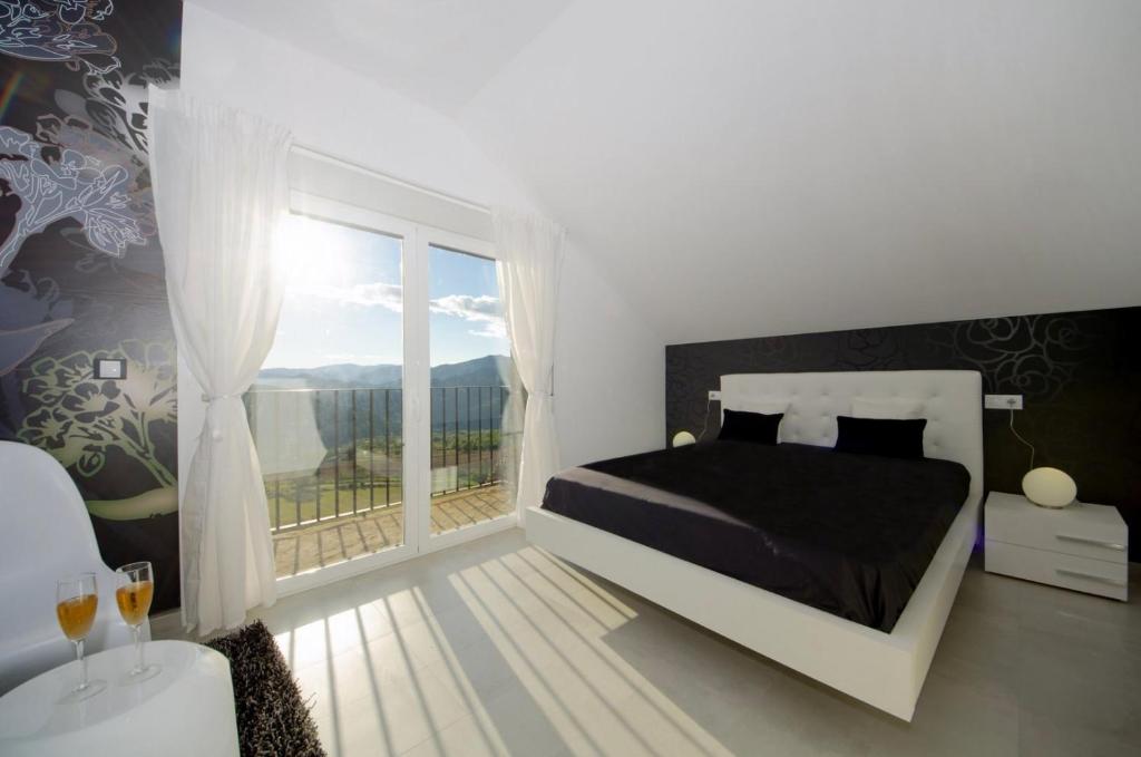 1 dormitorio con cama y ventana grande en Casa Rural La Esencia, en Araguás