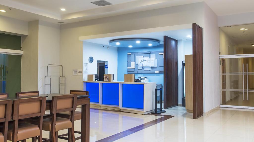une salle à manger avec une table et un comptoir bleu dans l'établissement Holiday Inn Express Manzanillo, an IHG Hotel, à Manzanillo