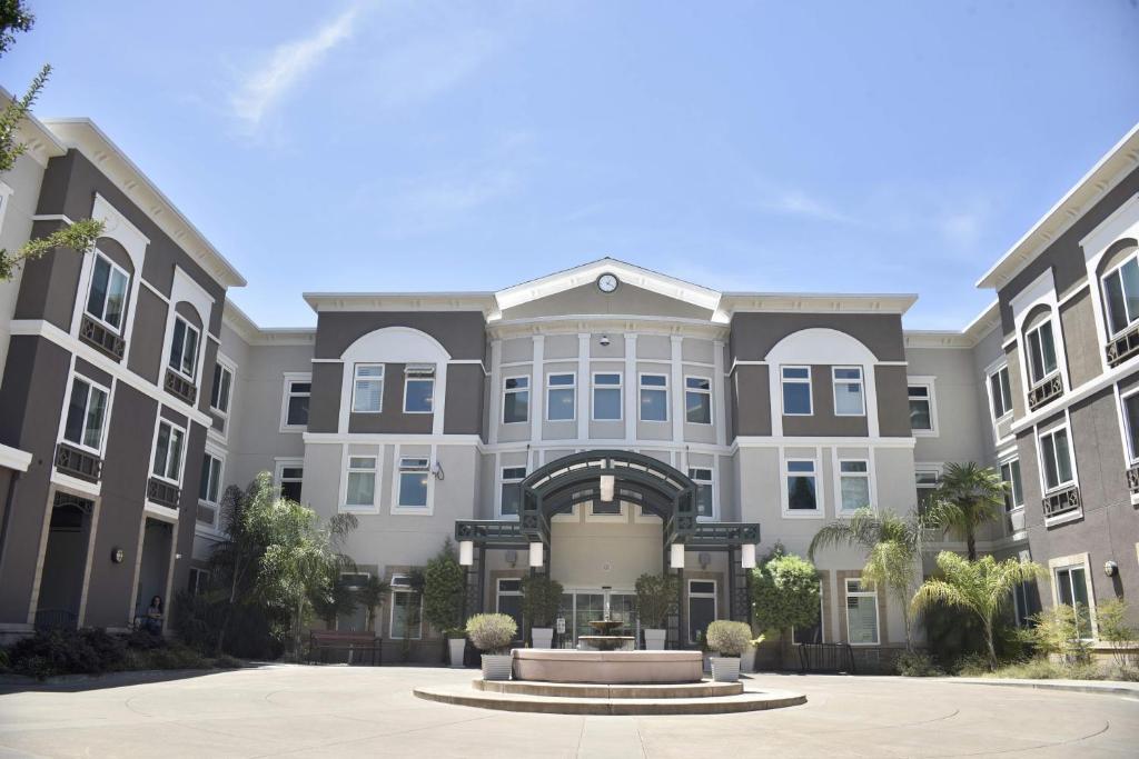 an apartment building with a fountain in the courtyard at Holiday Inn Express Windsor Sonoma Wine Country, an IHG Hotel in Windsor