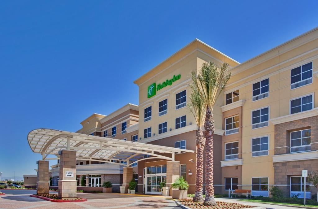 a hotel with a palm tree in front of it at Holiday Inn Ontario Airport - California, an IHG Hotel in Ontario