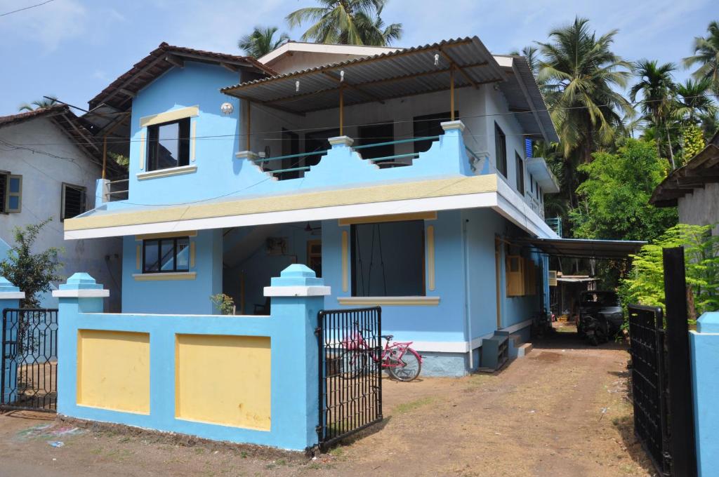 une maison bleue avec une clôture devant elle dans l'établissement Suvarna Holiday Home, à Kashid