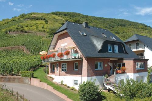 ein großes Haus mit Blumen auf dem Balkon in der Unterkunft Wein und Gästehaus Scheid in Sankt Aldegund